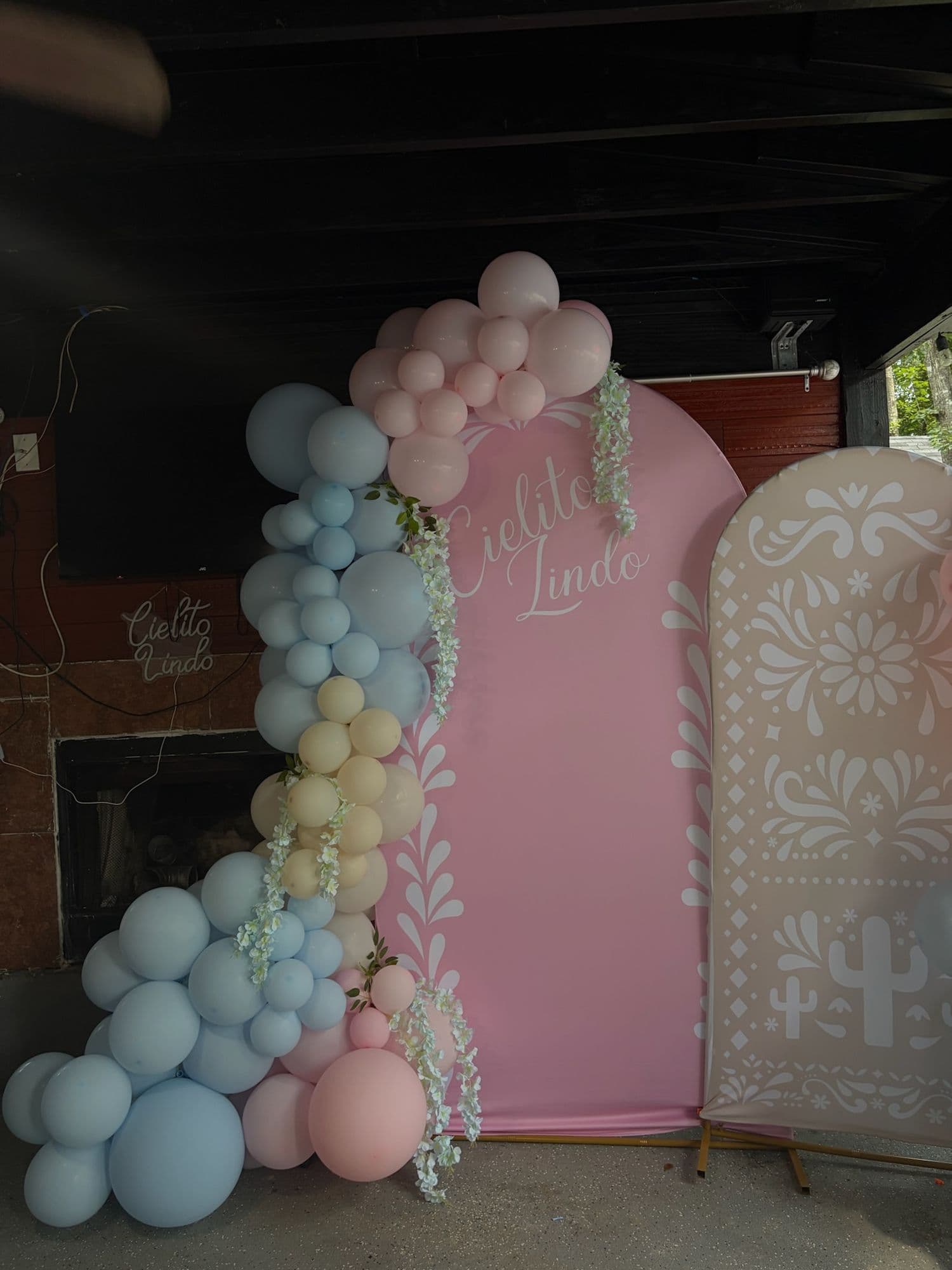 Arco rosa Cielito Lindo con panel de papel picado y guirnalda de globos pastel