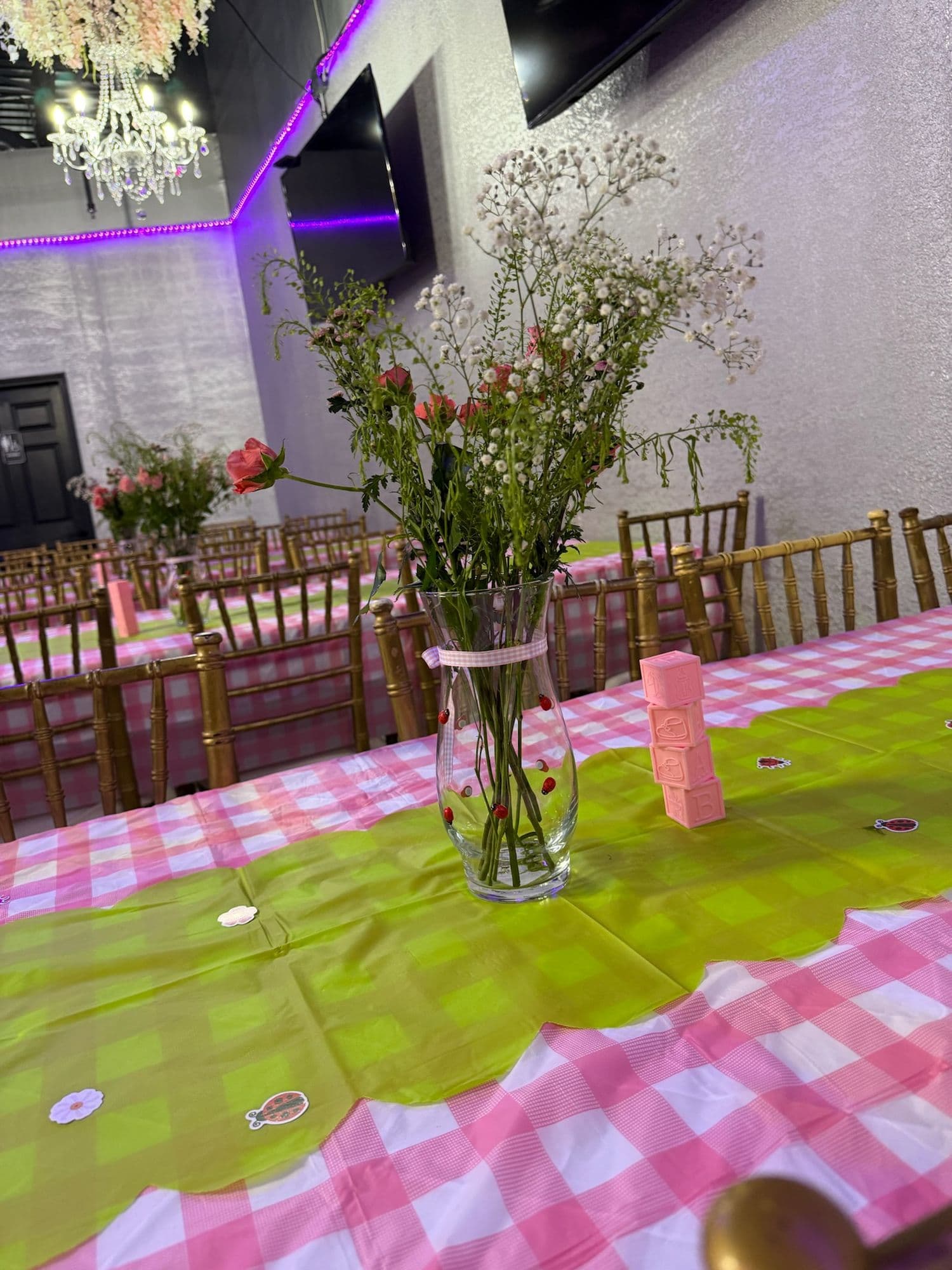 Centro de flores silvestres sobre una mesa en cuadros rosas y verde lima