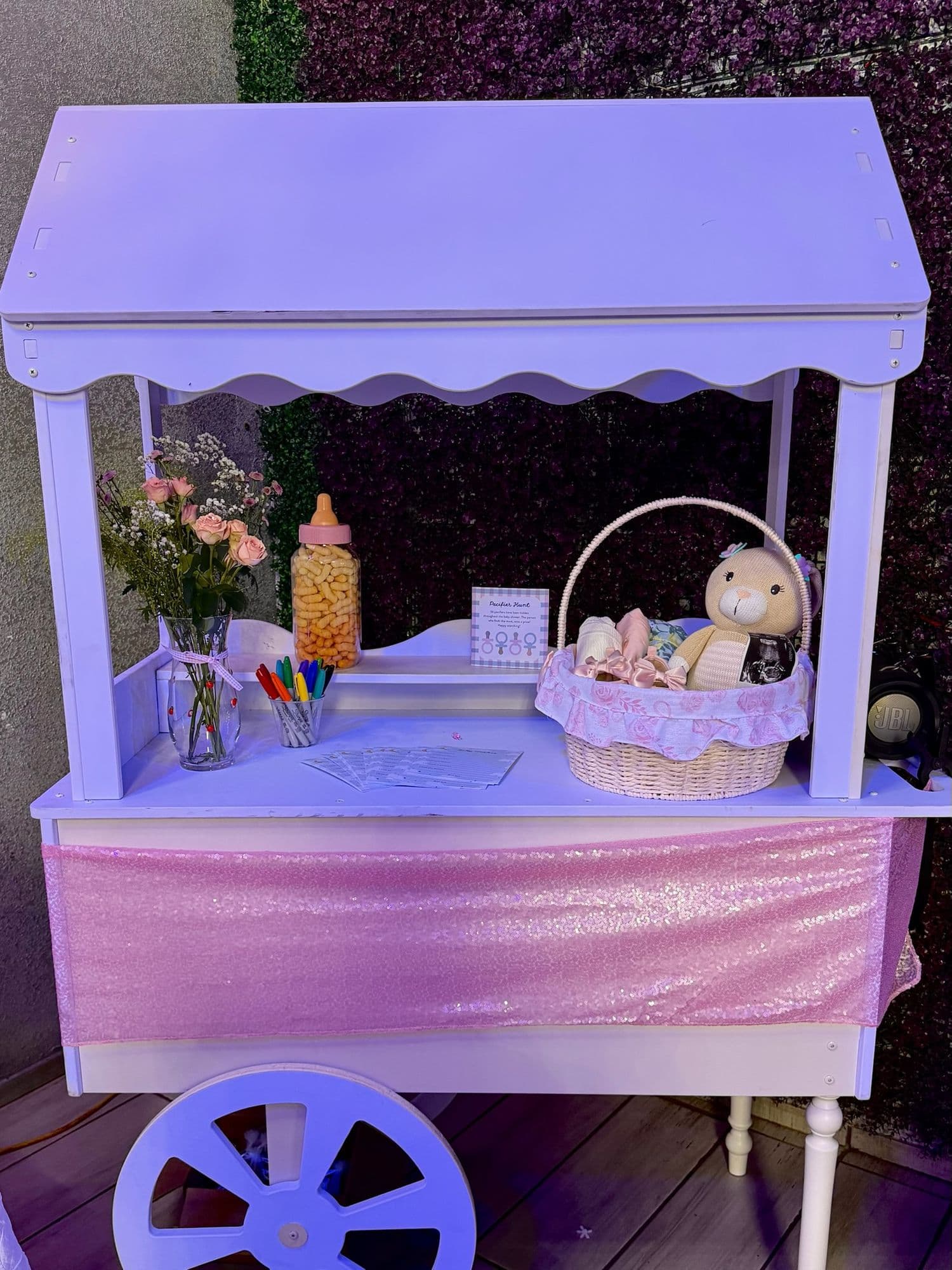 Carrito blanco decorado con canasta de regalo, flores y recuerdos