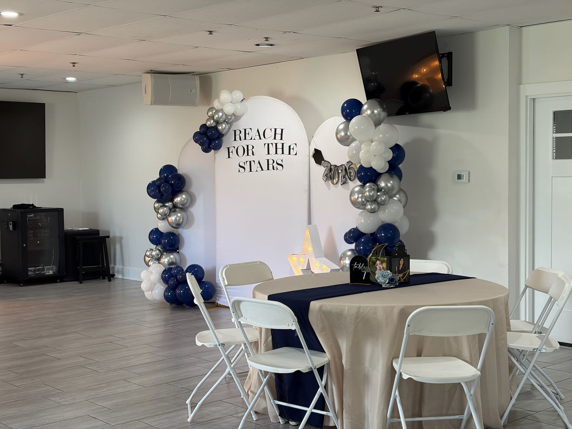 Reception room with navy runners, champagne linens, and the Reach for the Stars backdrop
