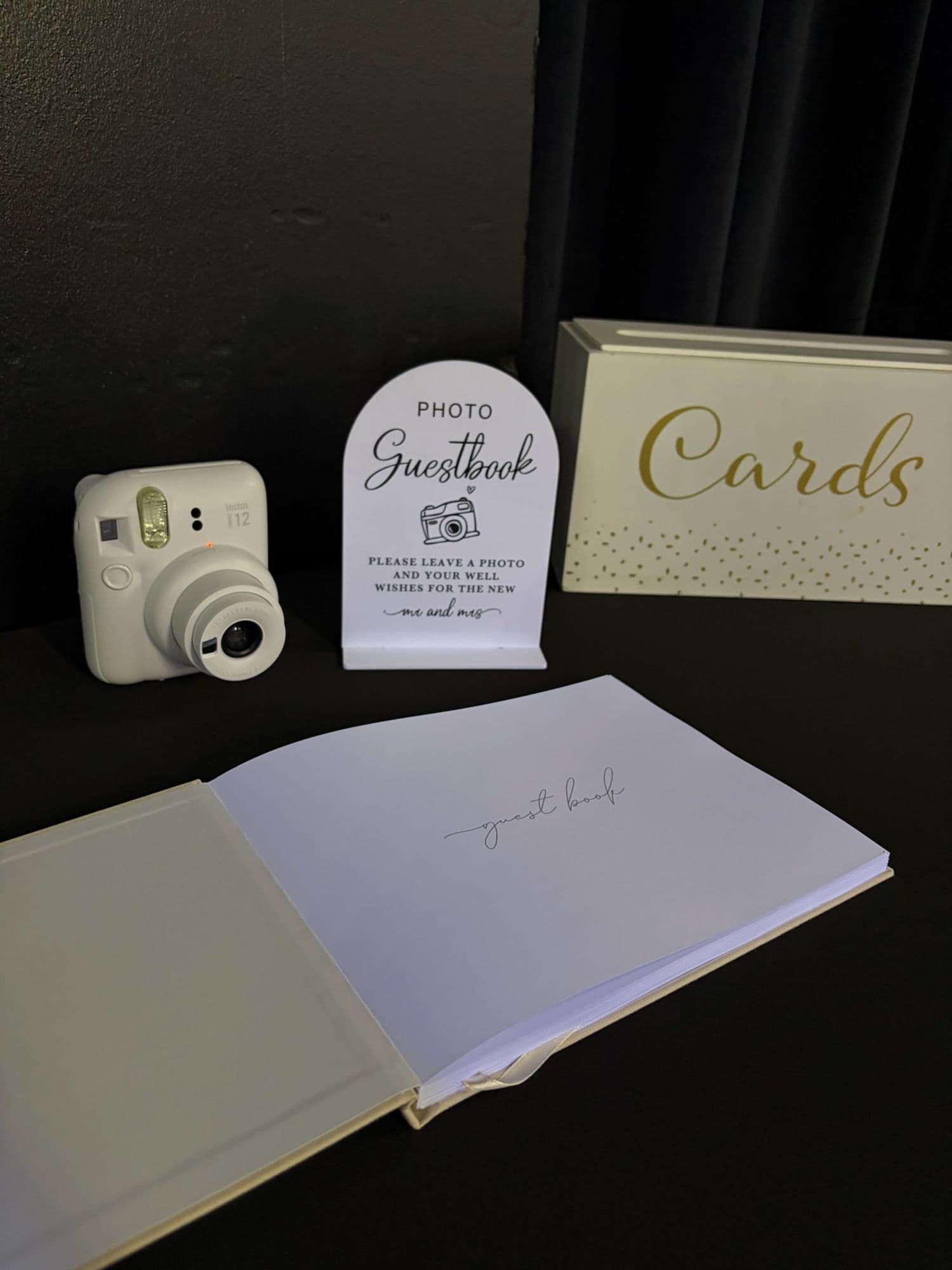 Photo guestbook station with an instant camera and a gold Cards box