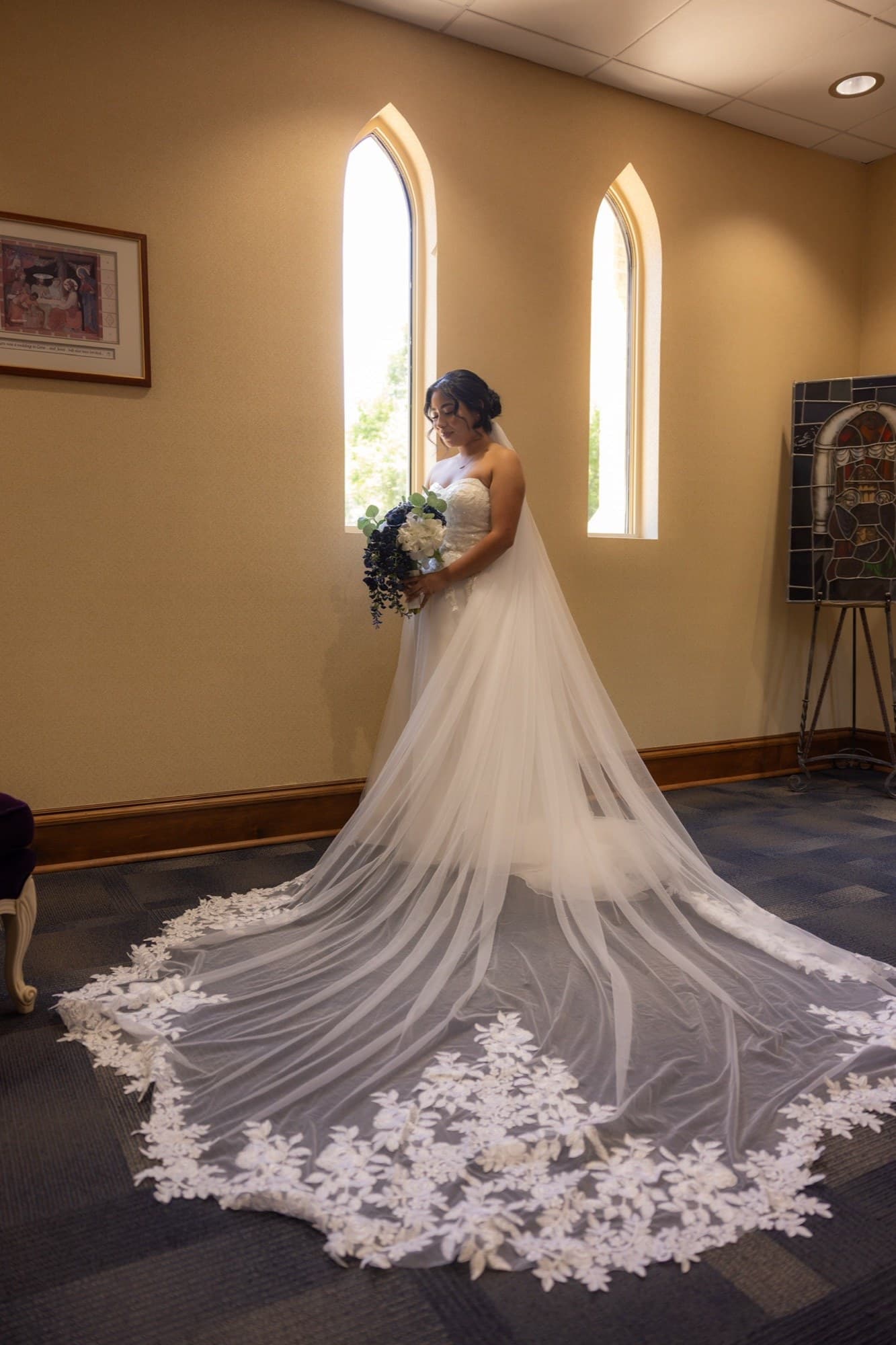 Bride with a cathedral-length lace veil spread across the floor
