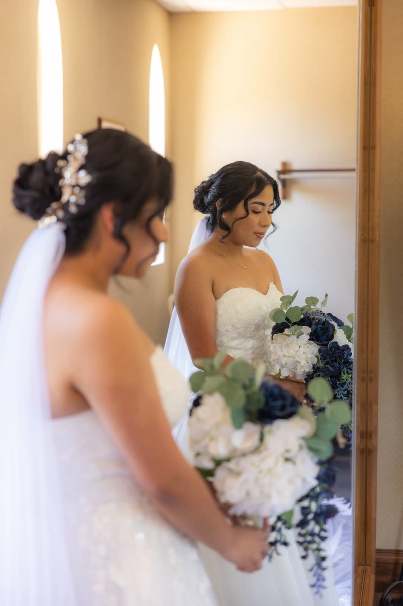 Bride holding a cascading navy and white rose bouquet