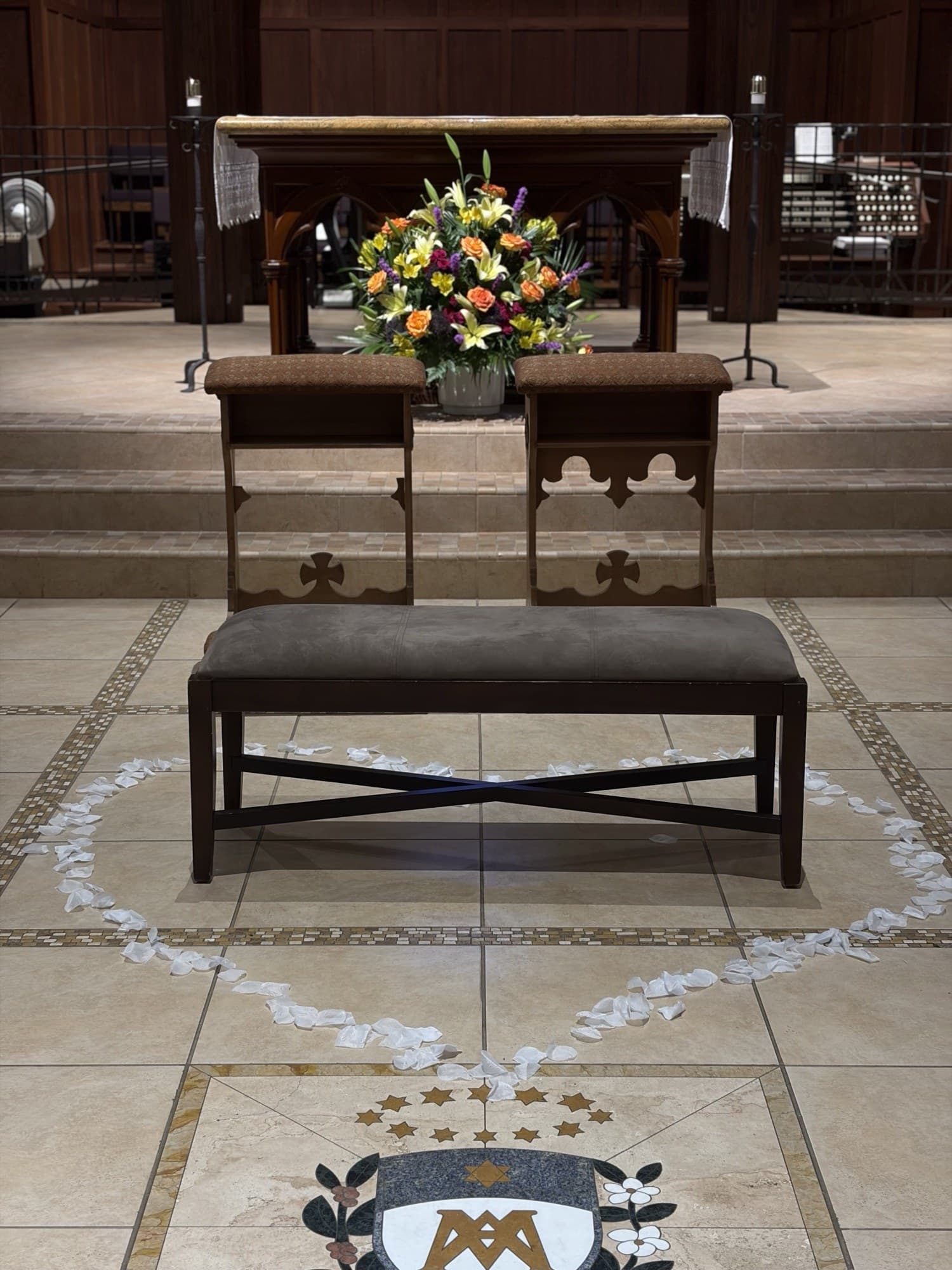 Church altar with a colorful floral arrangement and kneeler