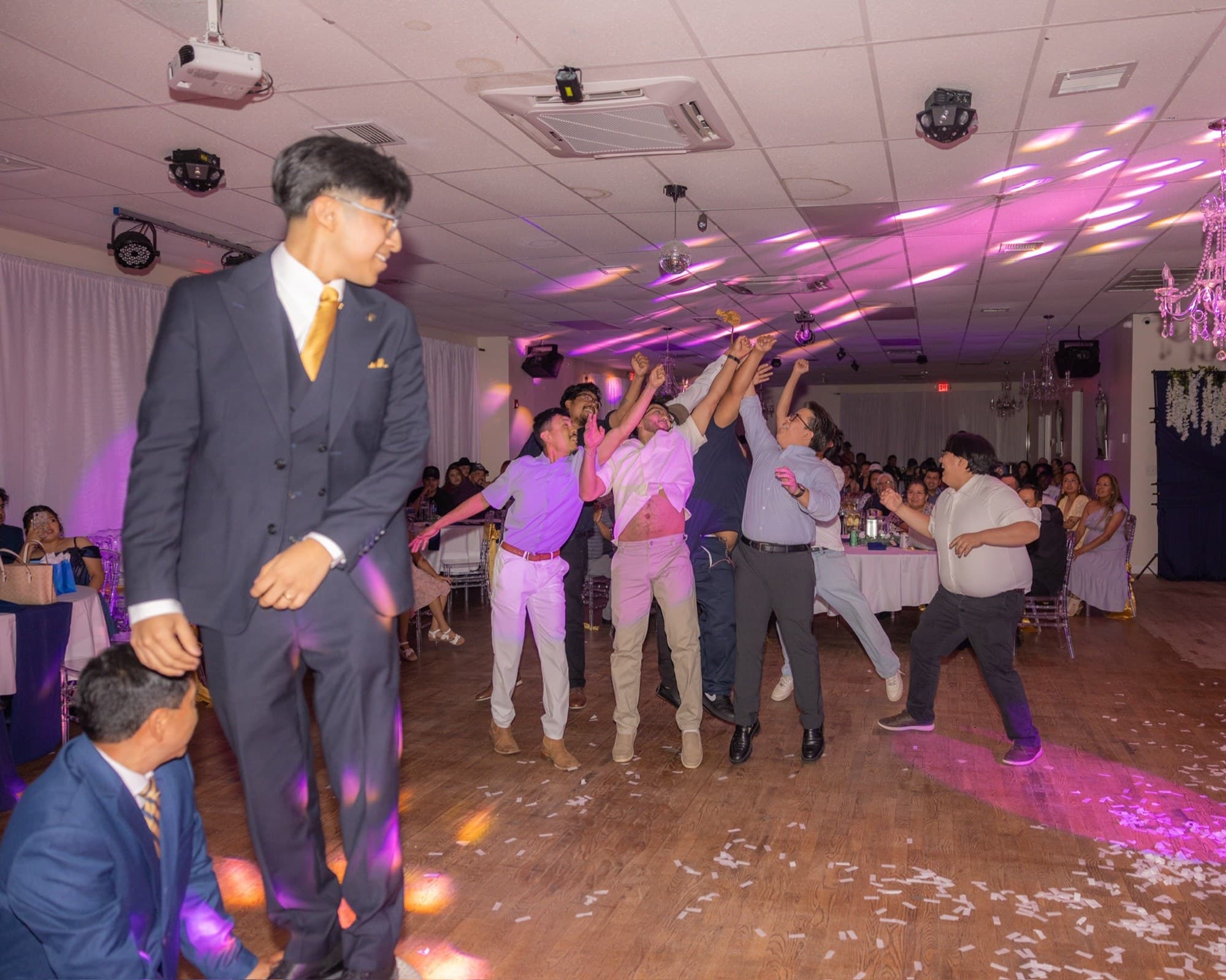 Groom tossing the garter to a crowd of guests