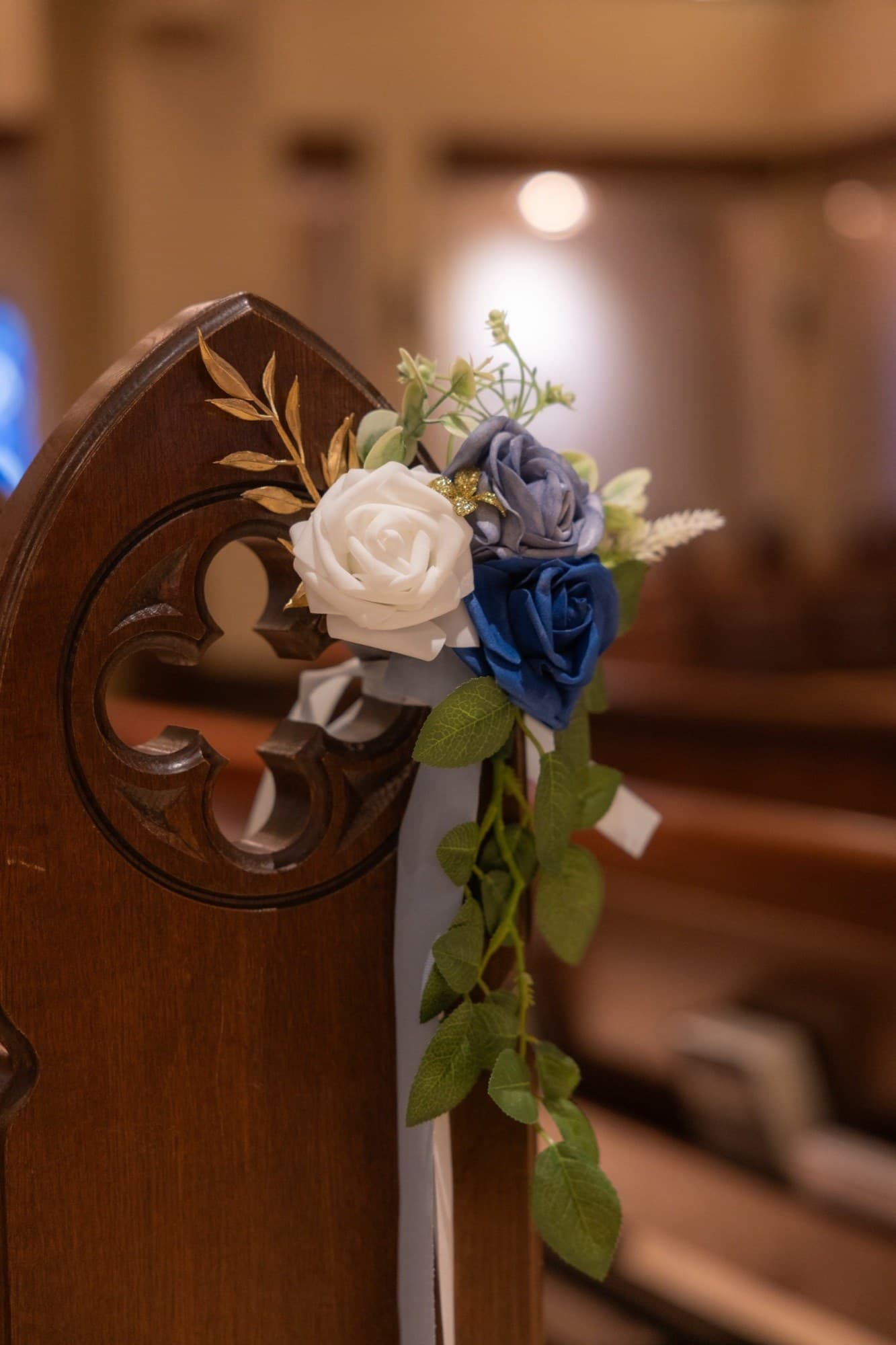 Navy, white, and gold rose spray on a carved church pew